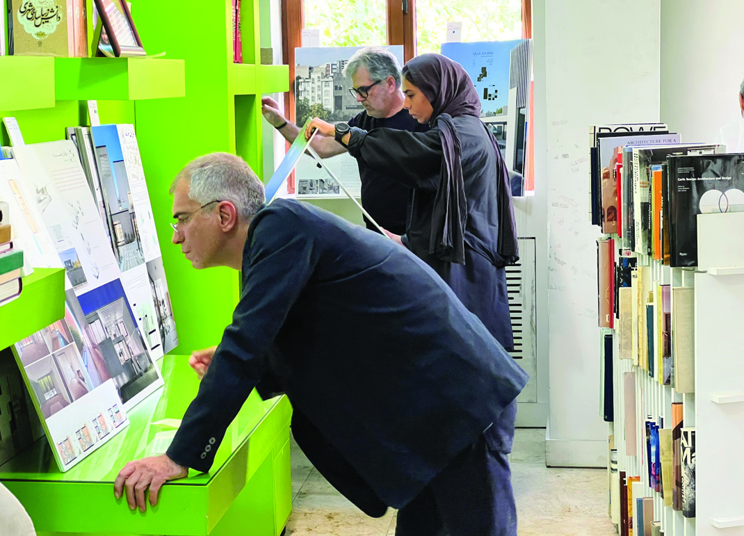 Jury members examining architectural submissions spread across a table during the 25th Memar Award