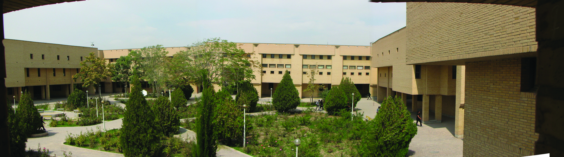 Panoramic view of central courtyard with mature trees and surrounding buildings