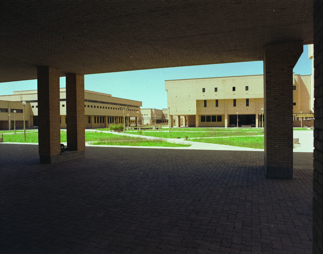 View of courtyard and buildings through colonnade with green lawns