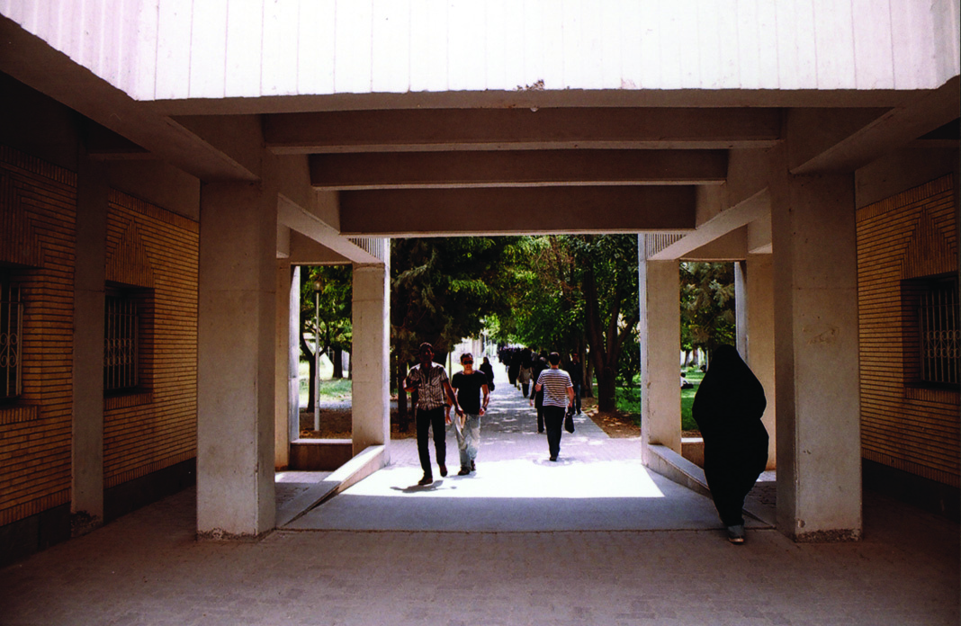 Covered walkway between university building blocks with students walking