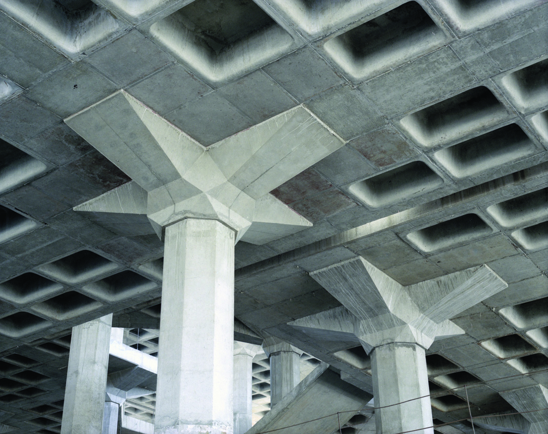 Interior structural detail showing concrete column capitals and coffered ceiling