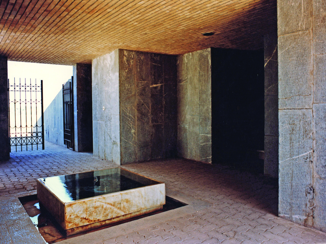 Prayer hall entrance with stone cladding and reflecting pool