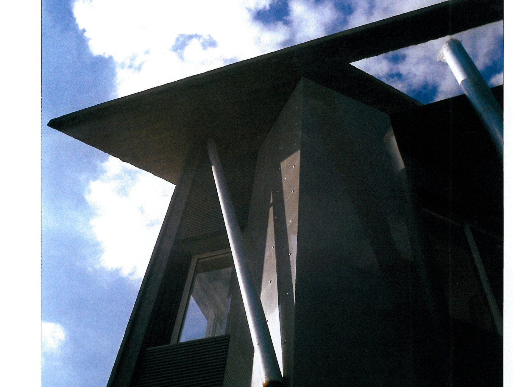 Dramatic angular roof detail of House Number 3, showing sharp geometric forms against the sky