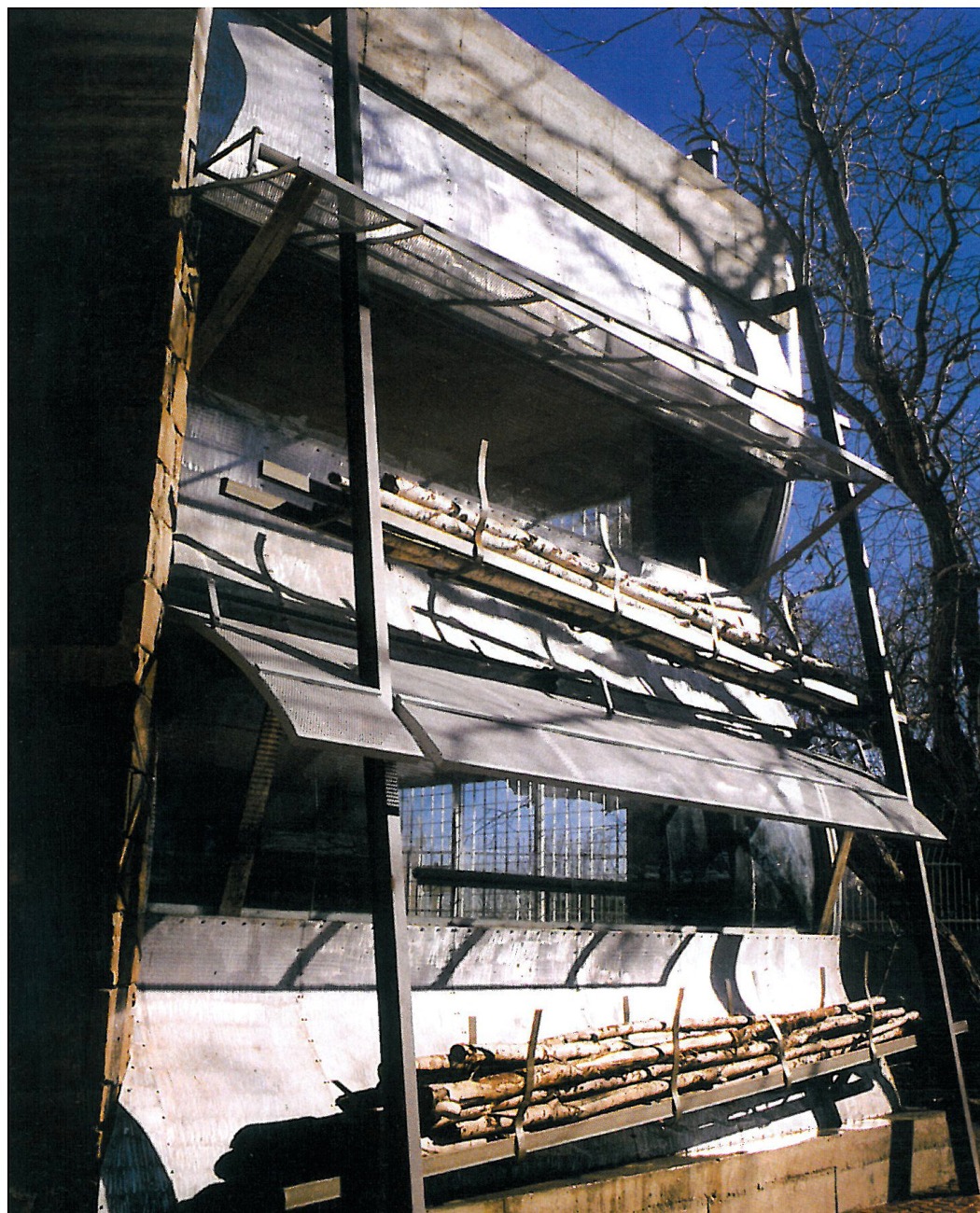 Exposed steel structure of House Number 3 rear facade with raw materials