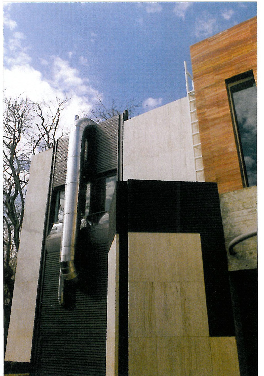 Front and entrance courtyard: brick and metal surfaces beside the white volumes
