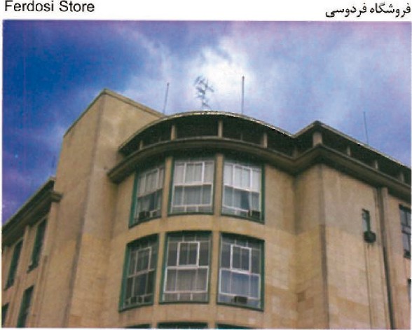Photograph of the Ferdosi Store building in Tehran — a corner of a curving 1950s reinforced-concrete frame with continuous metal-and-glass shopfronts on the upper floor.