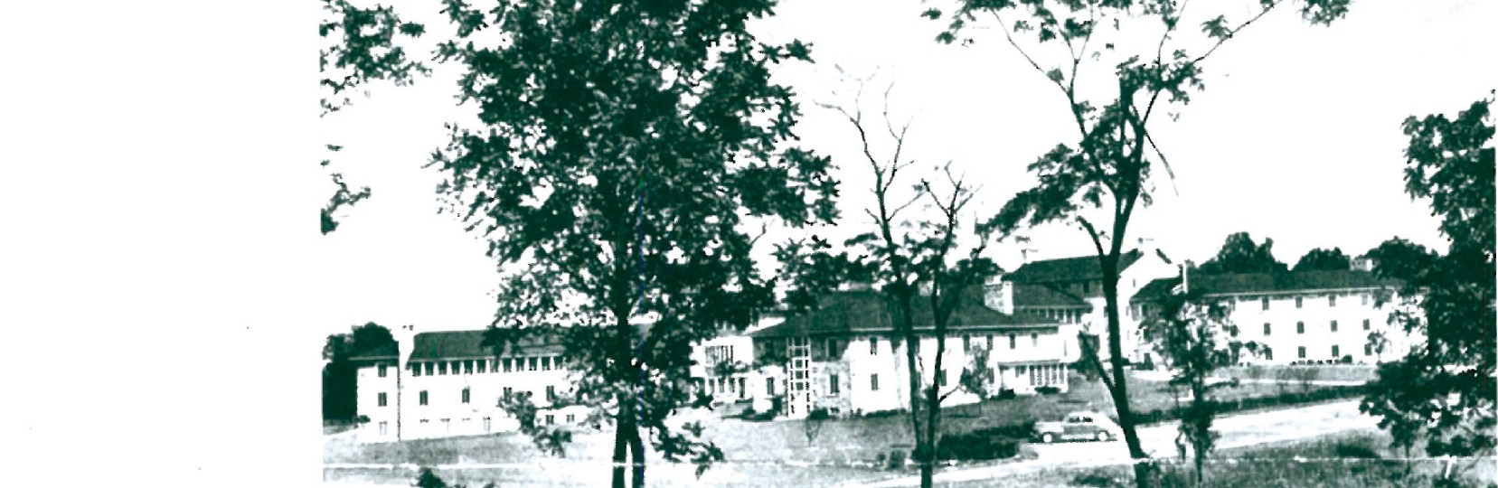 Mary Fisher Hall at Goucher College — long, low Moore-and-Hutchins residence hall set among mature trees on a sloping landscape.