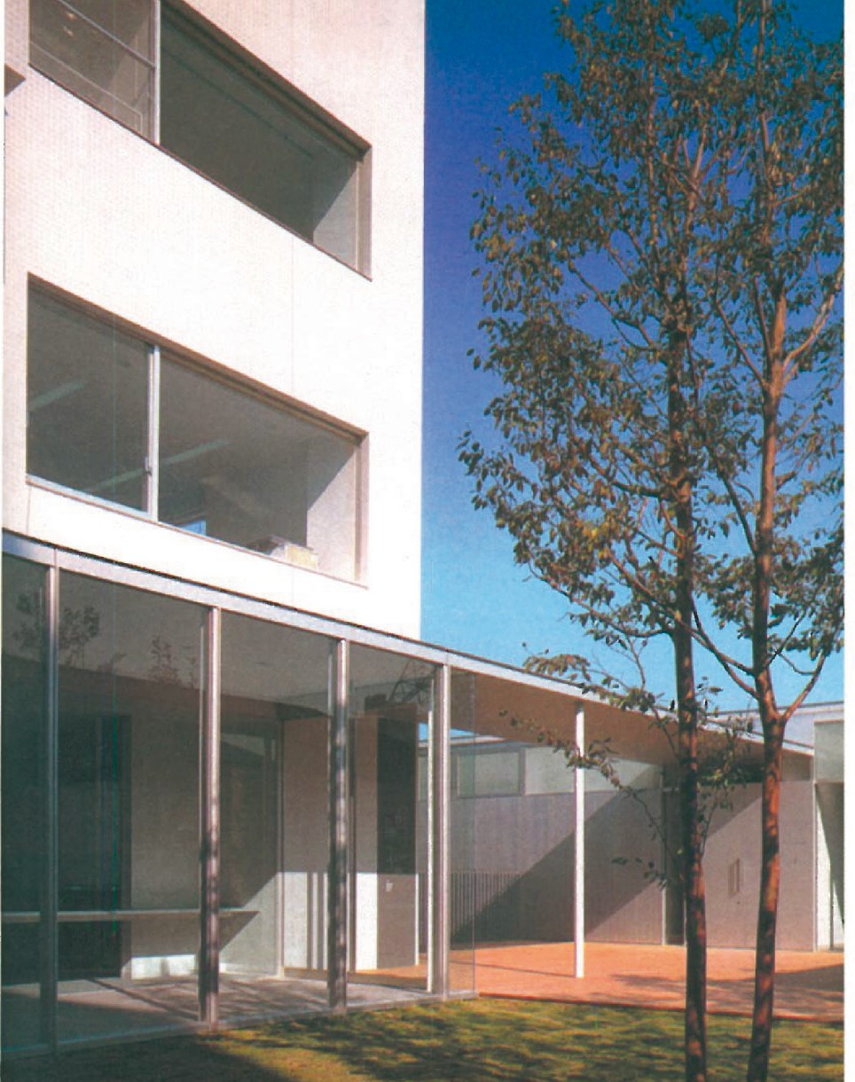 View of the public passage and apartment building at Hillside West, with the timber-louvred upper storey behind a tall street tree