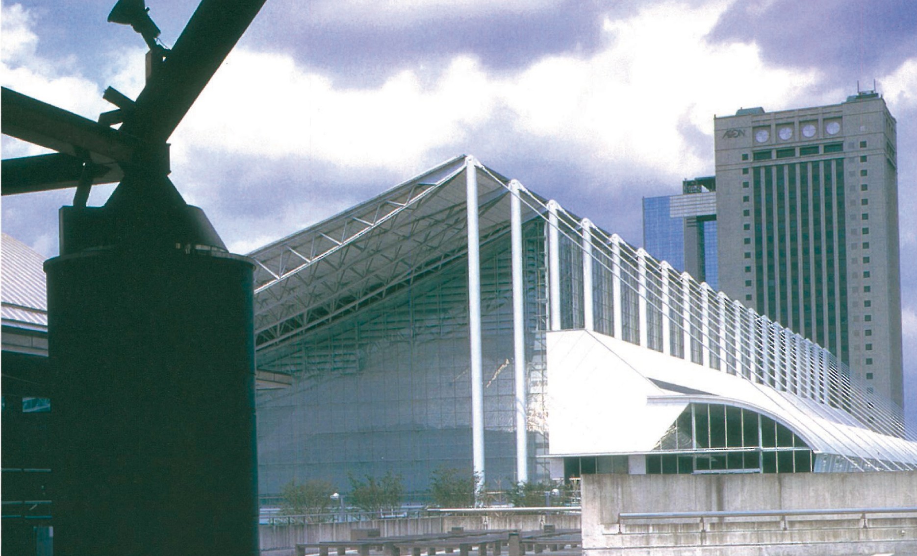 View from Phase I of Makuhari Messe toward the curved long-span steel canopy of Phase II (Nakase, 1997), the roof forms recalling sail boats and waves