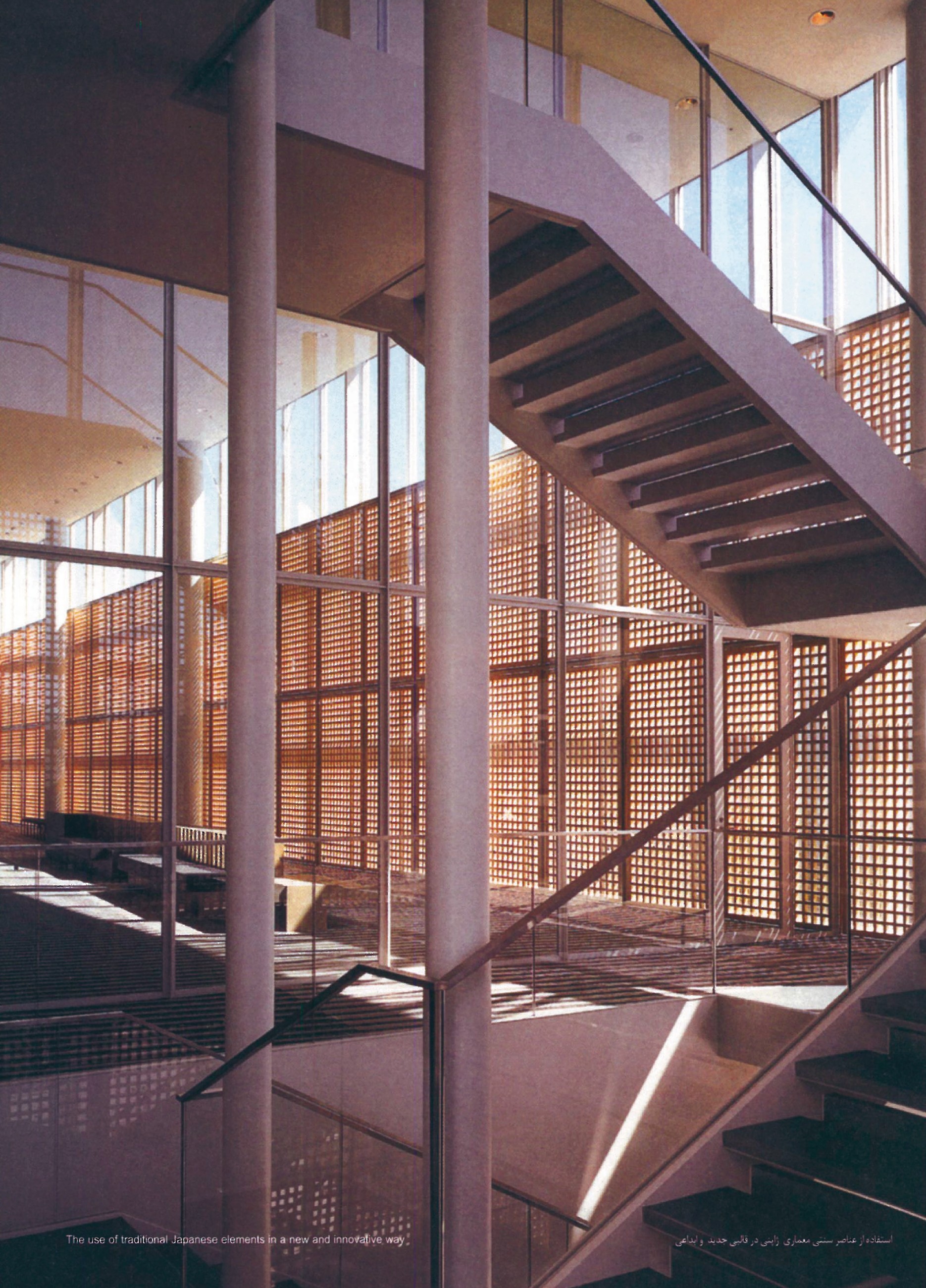 Detail view at the Toyama center: a polished concrete-and-steel staircase silhouetted against a tall lattice screen of timber squares and glass