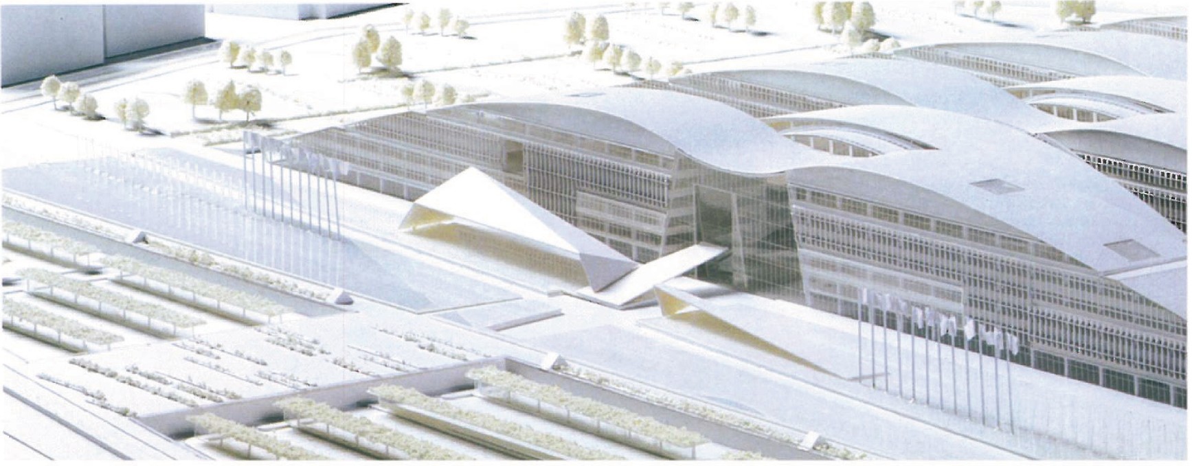 First-place scheme by SOM/ASSAR: oblique aerial render of the central conference block with its arched roof shells, with the row of national flagpoles in front of the entrance.