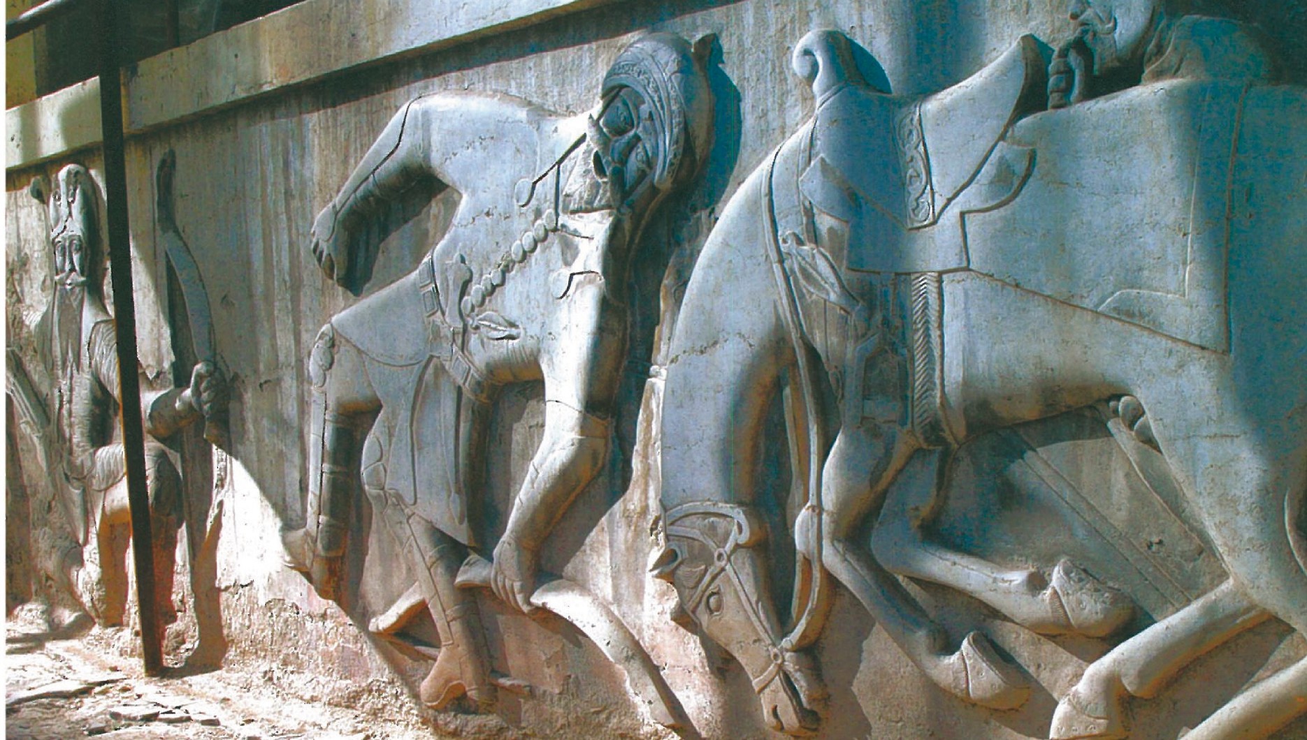 Large stone carving panel with a mythological subject: two horsemen carved into grey-blue stone