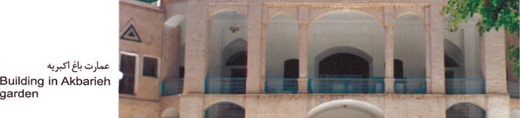 Two adjoining Birjand monuments: the Hosseyniyeh Shokatieh's tall pointed brick portal arch on the left and the Religious School's facade glimpsed at the upper edge