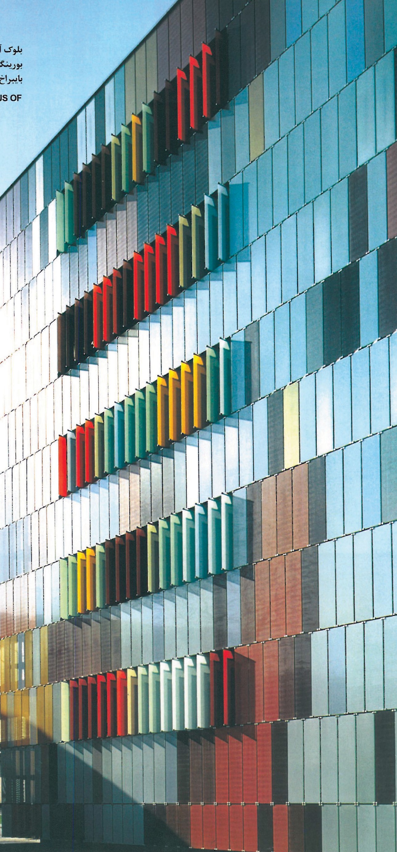Boehringer Ingelheim Pharma Laboratory Block by Sauerbruch & Hutton in Biberach — long curved glazed barrel facade composed of green, blue, yellow and violet square panels behind a screen of bare trees