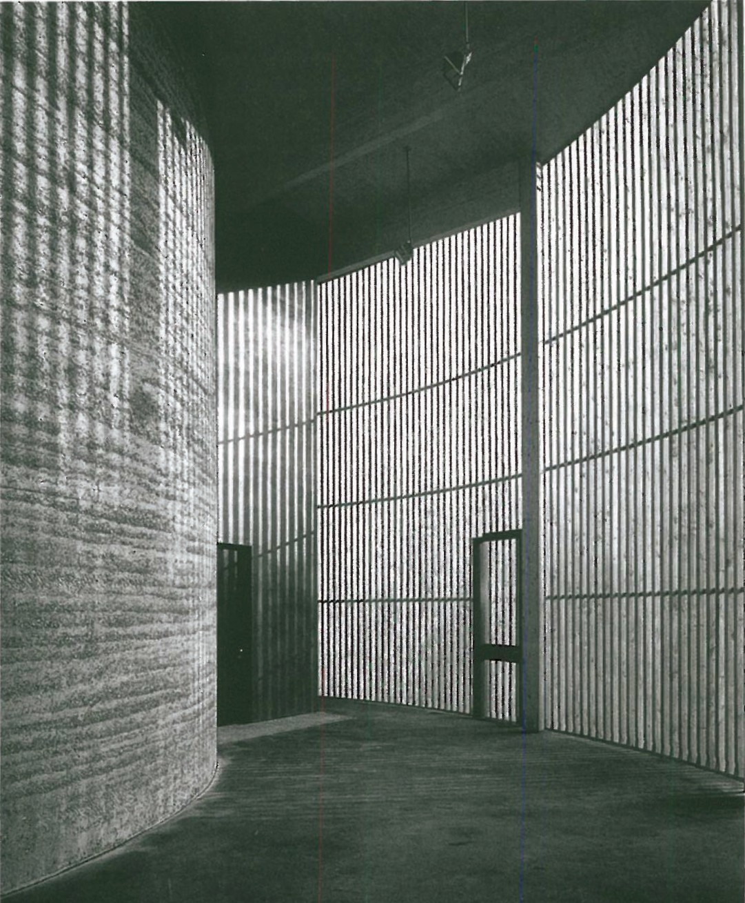 Curved rammed-earth interior of the Berlin Church of the Reconciliation (2000), light filtering through a vertical timber screen onto the textured earth wall