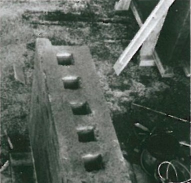 Top-down view of a long prefabricated rammed-earth module ready for assembly in the Pielach official-buildings project, showing recessed circular pockets