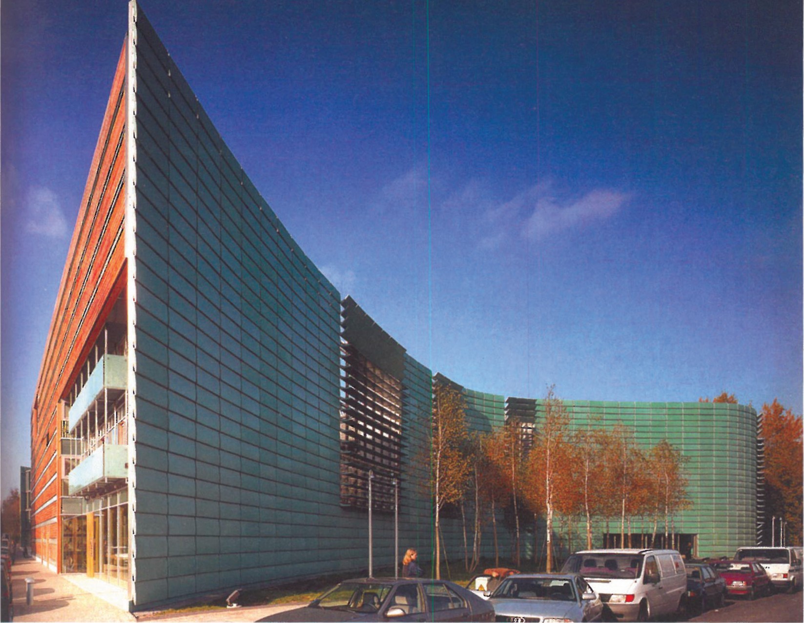 Nordic Embassies in Berlin — long curving wall clad in oxidized green-patina copper panels with a vertical louvered band facing the entry court and parked cars at the foot