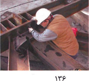 Worker inspecting the alignment of curved steel girts on the Walt Disney Concert Hall structural framework