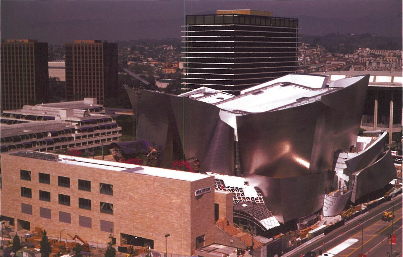 Walt Disney Concert Hall set within the Los Angeles downtown skyline, the curved stainless-steel exterior catching the afternoon light