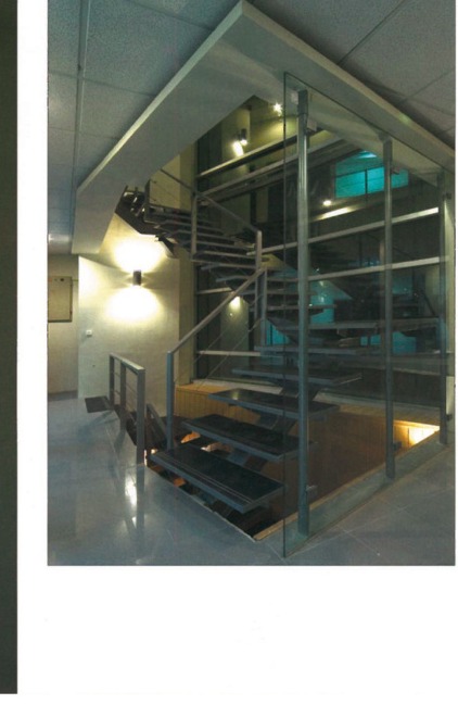 Interior staircase within glass enclosure at central void