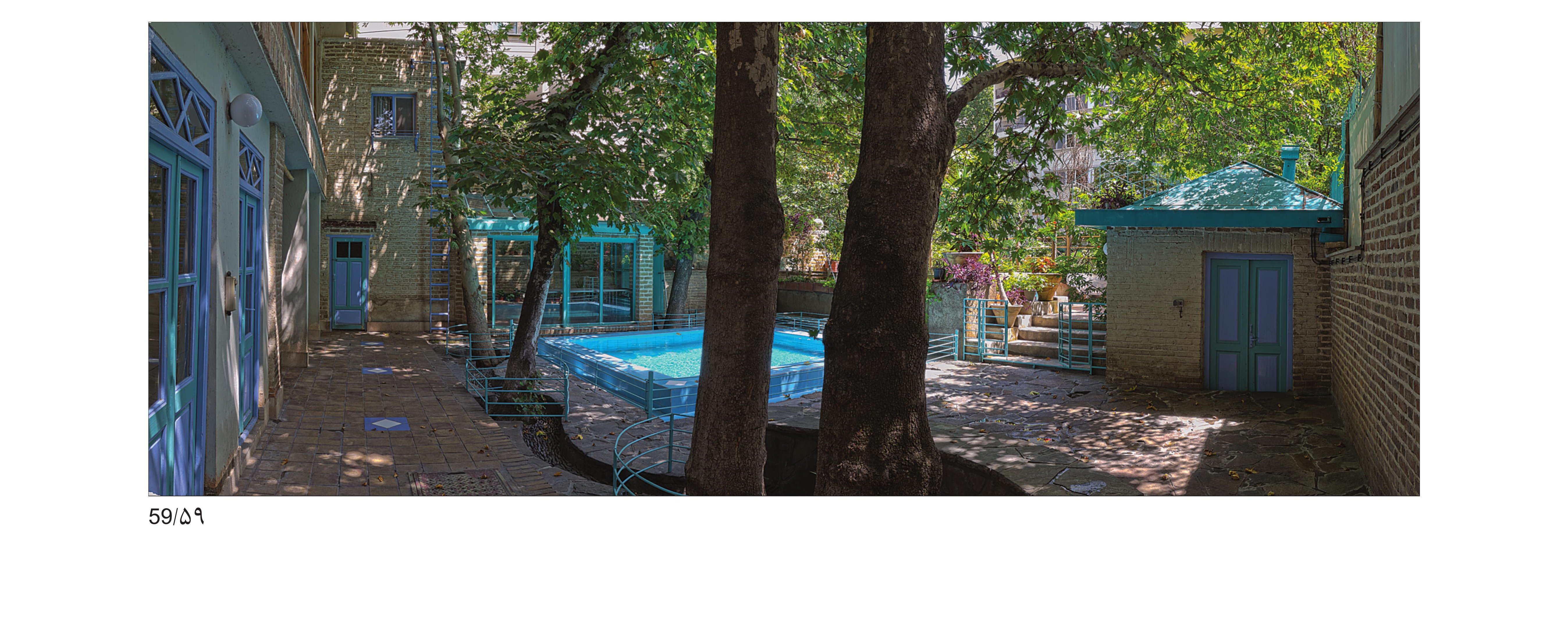 Looking down into the courtyard from the upper-west building — the new water pool, the kept tannour room and the old big trees at the river side.