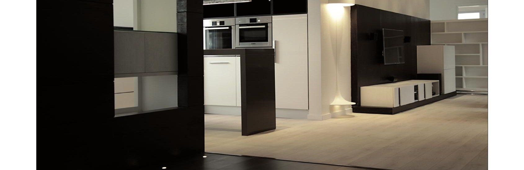 Open kitchen and living area at night with floor lamp glowing
