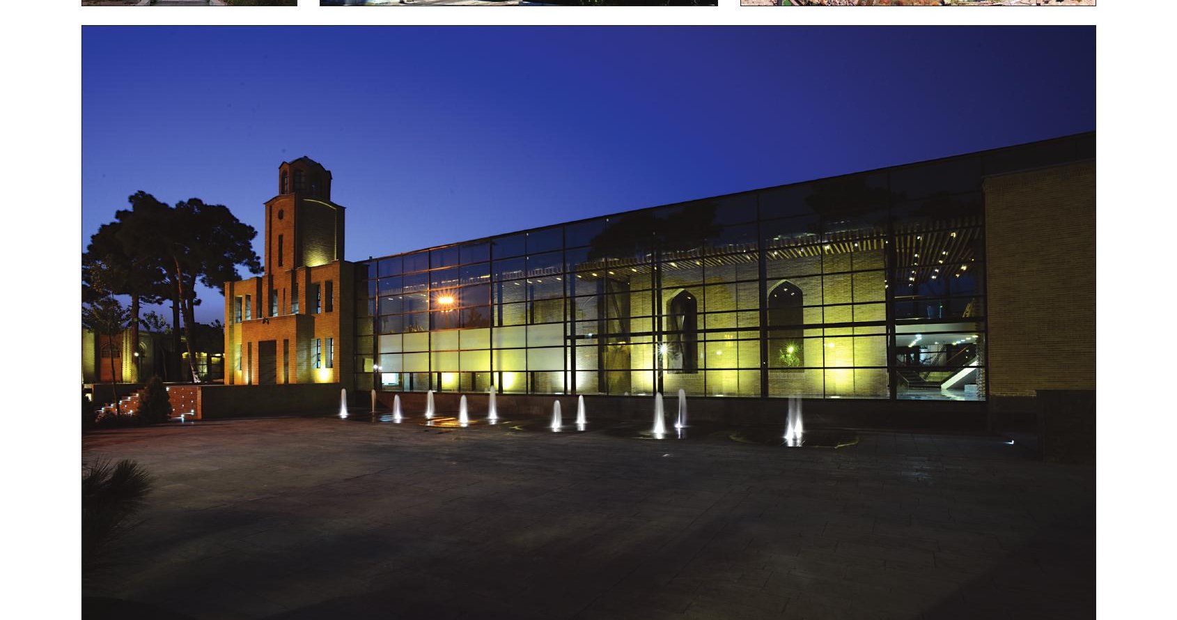 The new museum block illuminated at dusk, with the historic tower at left