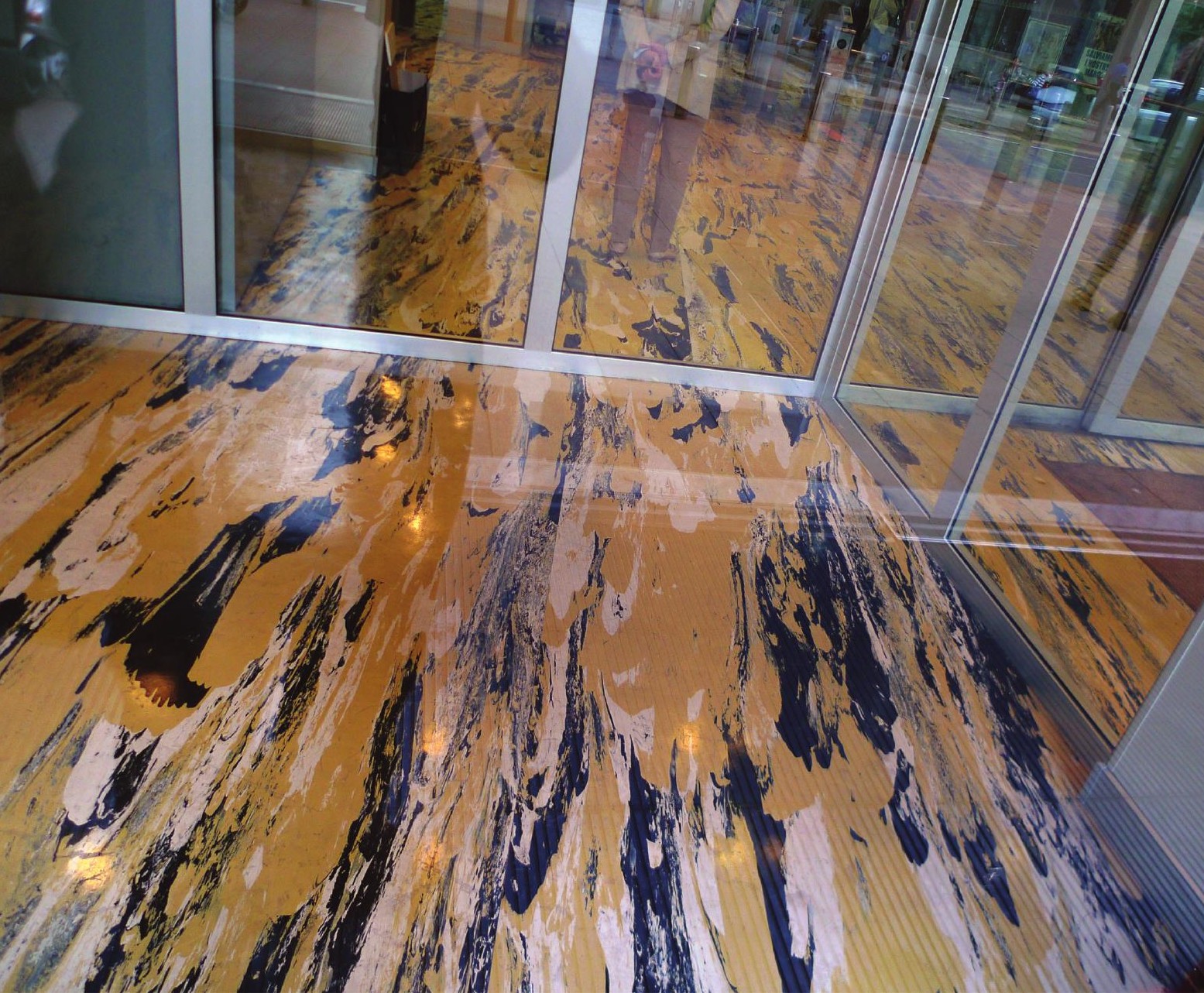 The patterned entrance-foyer floor seen through the glazed façade