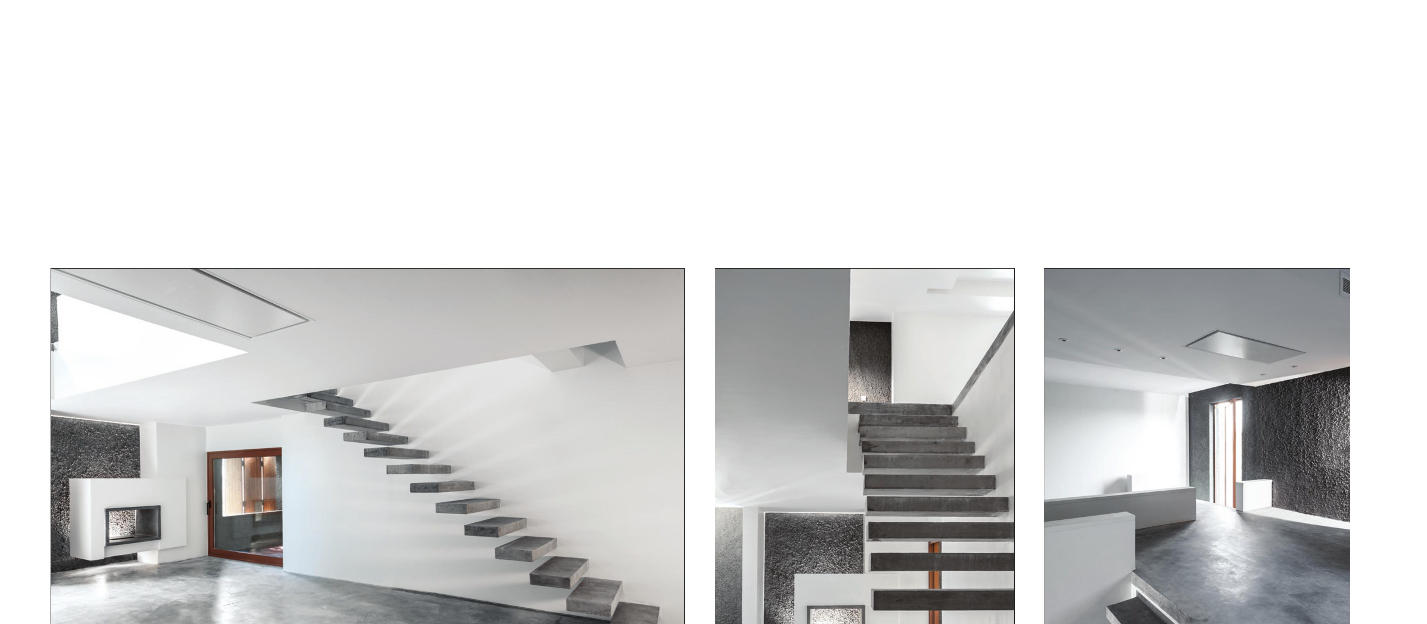 Living rooms with the cantilevered stair — concrete skin folds inside as a textured wall.