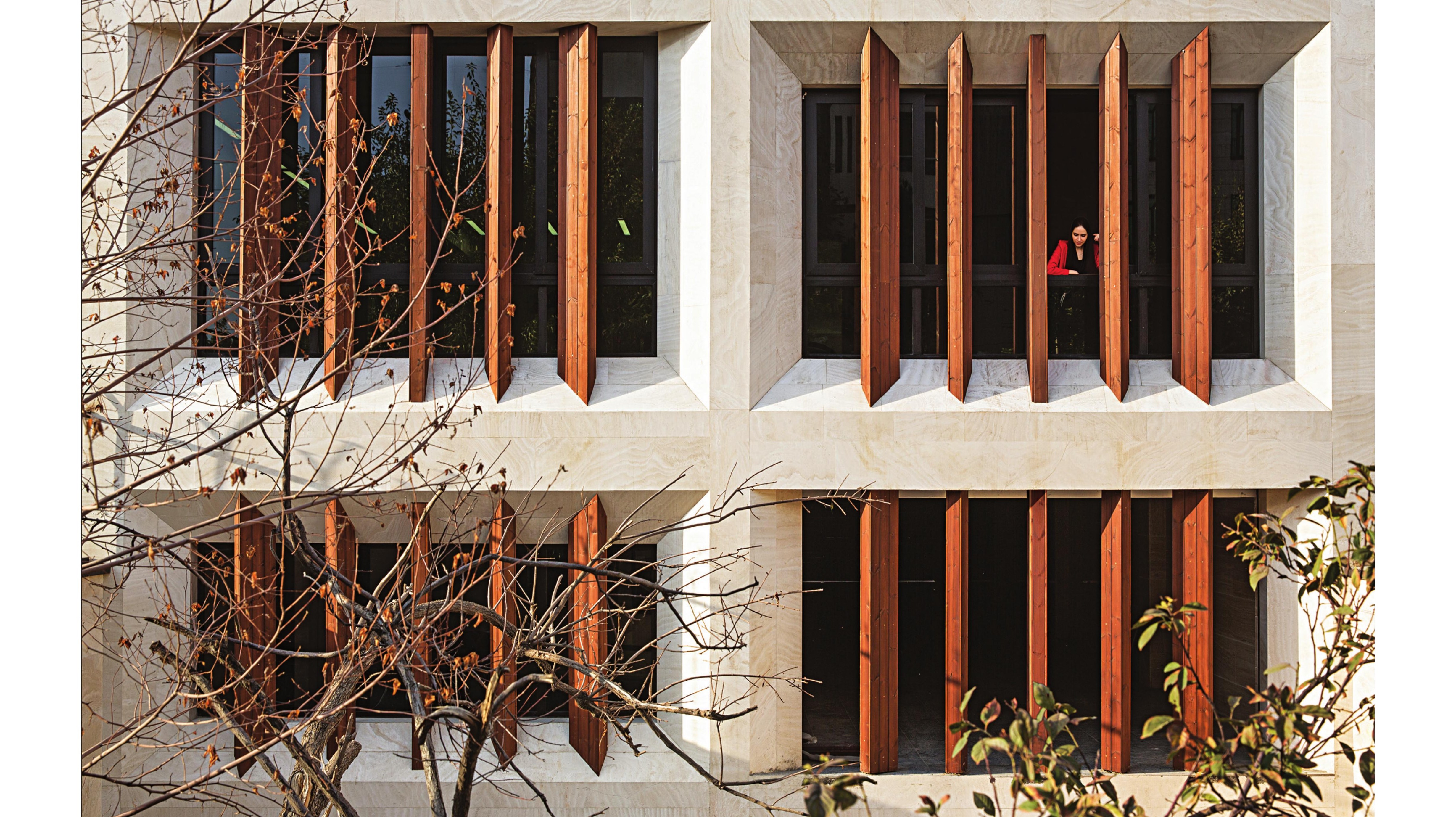 Pivoting timber louvers on the office facade, opening selectively to the street.