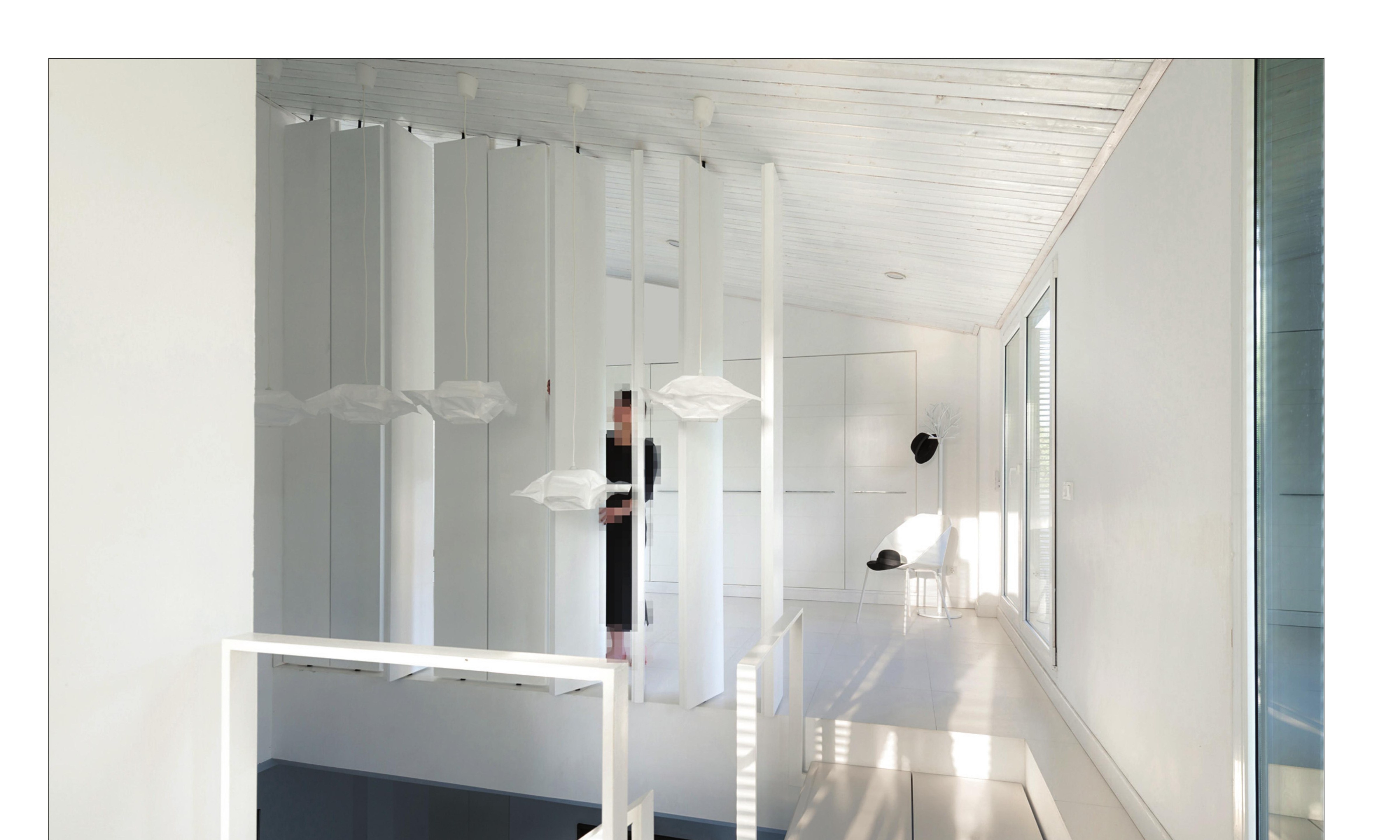 Upper-floor view: the inhabitant on the threshold between bedroom and the slatted screen that veils the void.