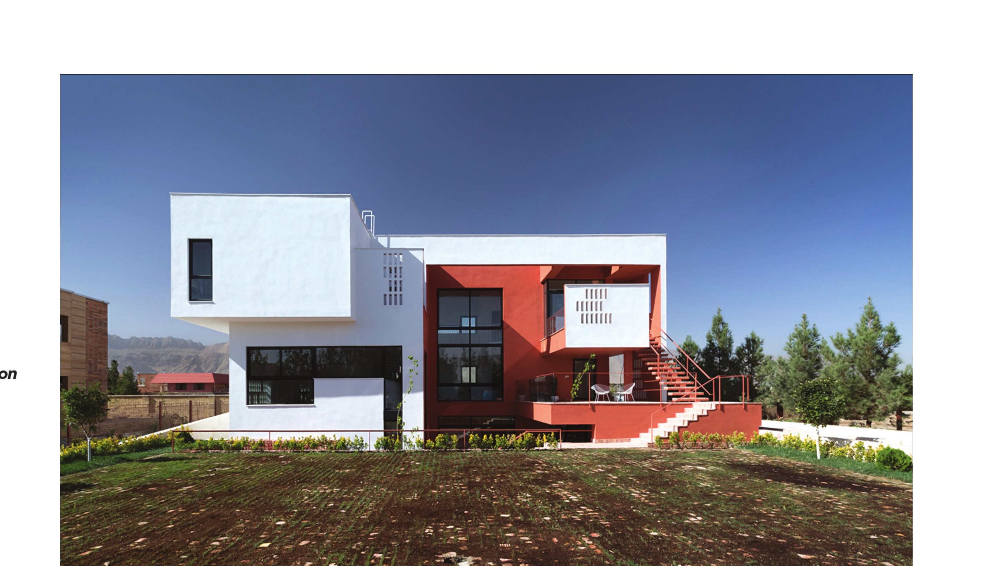 External view: the red brick volume facing the road, with the introverted court hidden behind.