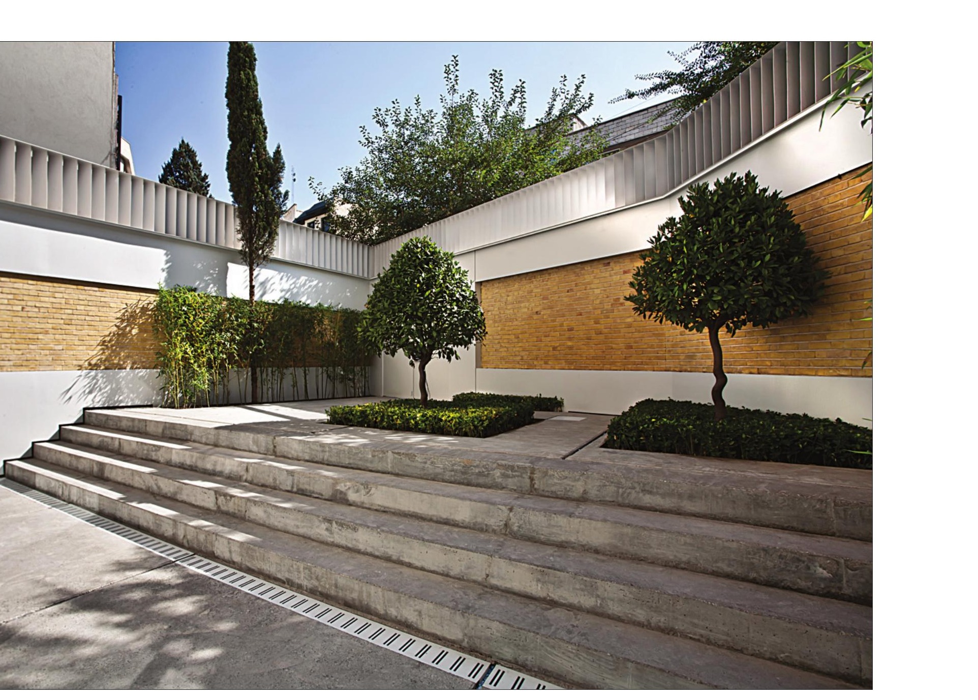 Courtyard with cypress trees and stepped travertine planters seen from above