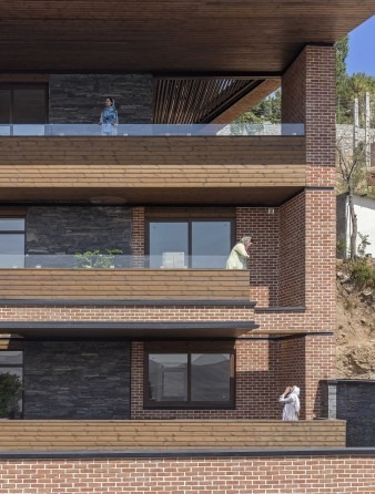 Detail of stacked brick balconies with figures on three different floors
