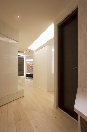 Living room with sliding glass door, recessed ceiling lighting and timber floor