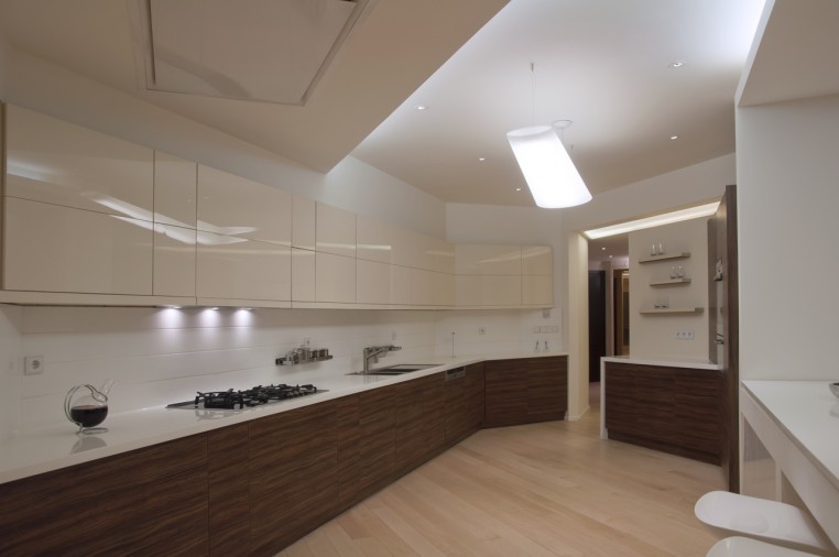 Modern kitchen with high-gloss cream cabinets and pendant lamp