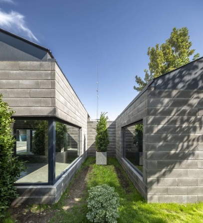 Grass courtyard between two concrete-block volumes