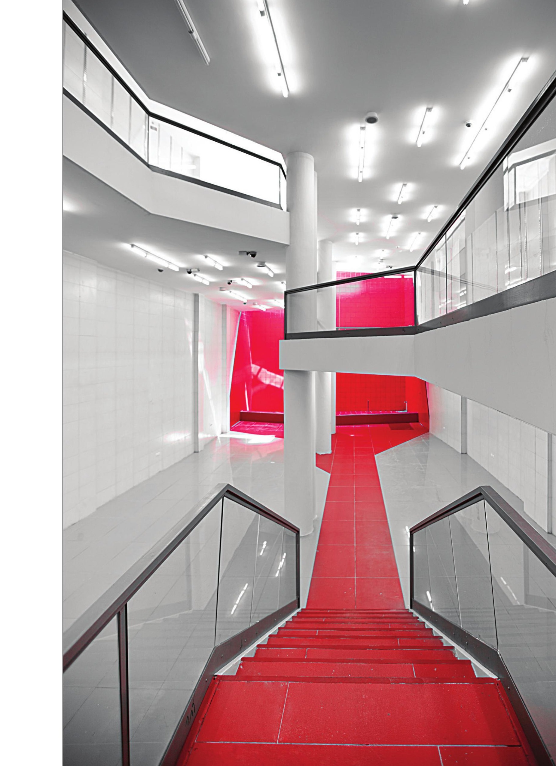 Interior view of the red gentle-slope stair drawing visitors through the four half-floors