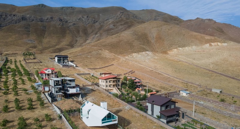 Aerial view of the villa within its elongated site against the bare slopes of Damavand in summer