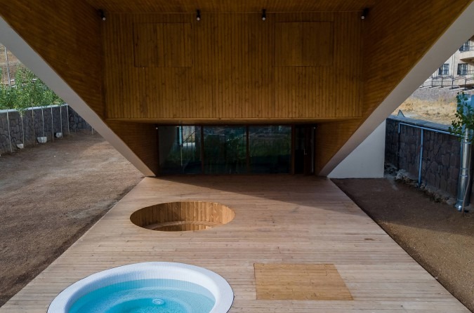 Wood deck under the cantilever with the circular skylight cutout opening to the pool above