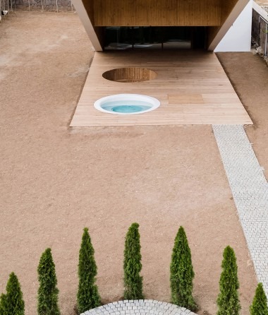 Top-down view of the sunken courtyard with circular jacuzzi and gravel garden
