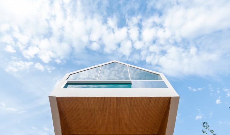 Looking straight up at the underside of the gable and skylight against the sky