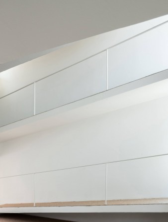 Sloped white wall surface of the indoor ramp shown in close-up