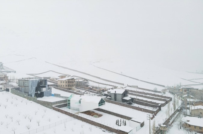 Snowy day view with the villa in the middle ground and snow-blanketed orchards behind