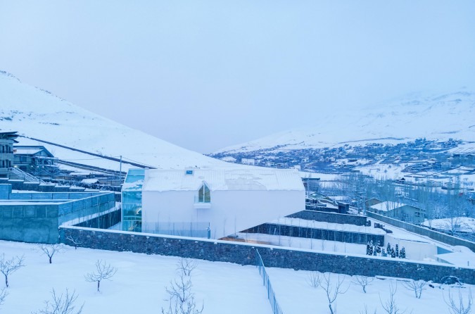 Snow panorama with the villa surrounded by orchards and the village beyond