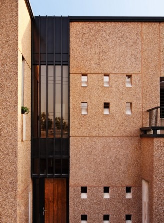 Brick facade with grid of small square windows and steel grille