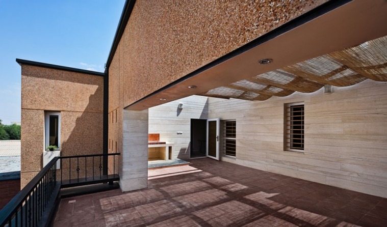 Brick massing with deep punched-square reveals at courtyard side