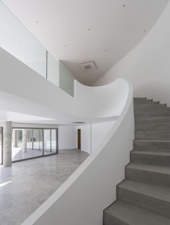 Interior of the villa with floor-to-ceiling windows opening to the pool deck