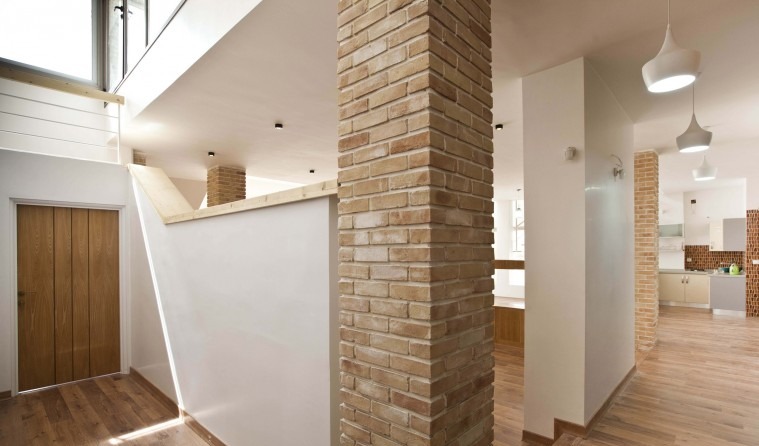 Interior with exposed brick column and stair to upper floor