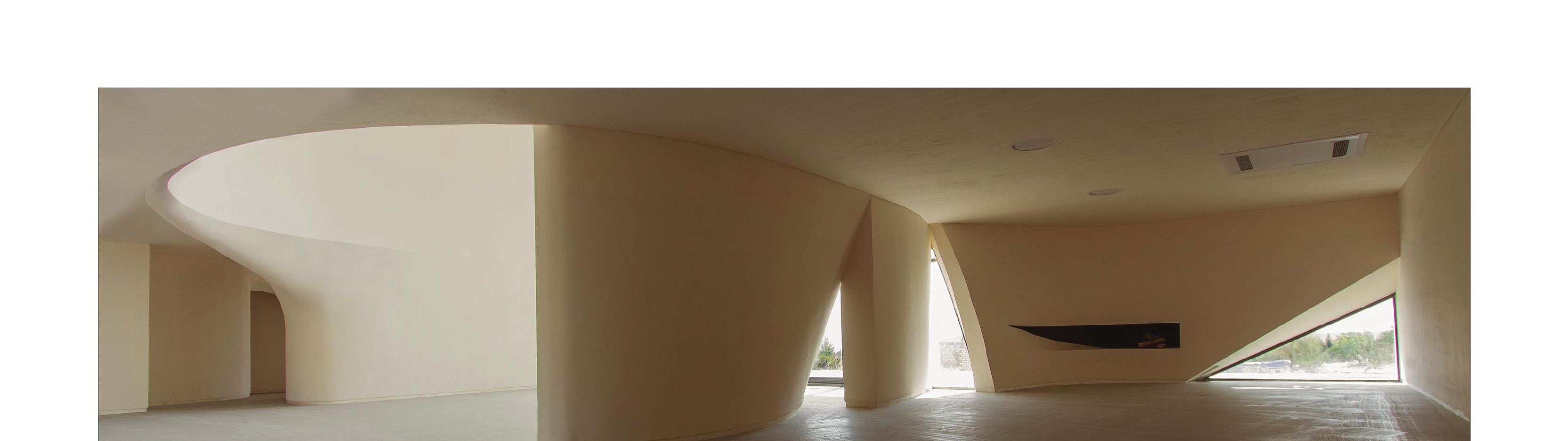 Wide interior panorama showing curved walls absorbing the columns